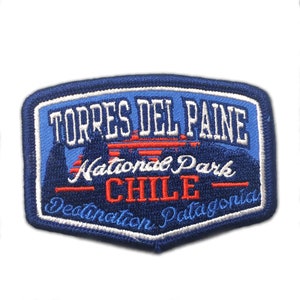May include: A blue and white embroidered patch with the text "Torres del Paine National Park - Chile - Destination Patagonia".