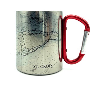 May include: A stainless steel travel mug with a red carabiner handle. The mug features a nautical map of St. Croix.