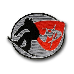 May include: A black and white embroidered patch of a person snowboarding with a red and white logo that says "JFP" in the background.