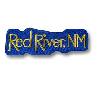 May include: Blue embroidered patch with the text "Red River, NM" in gold thread.