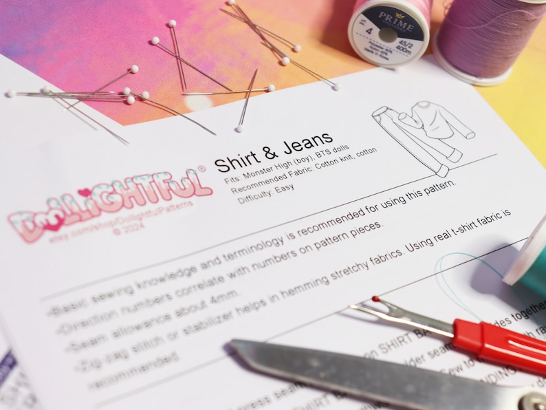 May include: A white sheet of paper with the text "Shirt & Jeans" and a line drawing of a shirt and jeans. The text "Dlightful" is in a colorful font at the top of the page. The paper is surrounded by sewing supplies, including pins, thread, and a seam ripper.