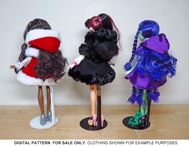 May include: Three fashion dolls wearing different outfits. The doll on the left is wearing a red and white hooded dress. The doll in the middle is wearing a black hooded dress with white polka dots. The doll on the right is wearing a purple hooded dress with green accents.