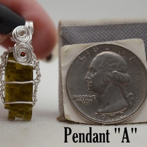 May include: A handmade pendant with a rectangular, olive-green stone encased in silver wire. The pendant is labeled "Pendant 'A'" and is shown next to a U.S. quarter for size comparison.