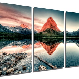 May include: A panoramic view of a mountain lake with a red mountain reflected in the water. The sky is a vibrant pink and orange, creating a beautiful sunset scene.