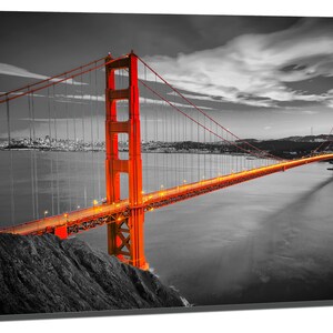 K&ouml;nnte beinhalten: Ein Schwarzwei&szlig;foto der Golden Gate Bridge in San Francisco, Kalifornien. Die Br&uuml;cke ist in Orange beleuchtet, w&auml;hrend Himmel und Wasser in Schwarzwei&szlig; gehalten sind.