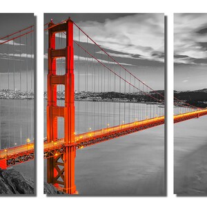 K&ouml;nnte beinhalten: Ein Schwarzwei&szlig;foto der Golden Gate Bridge in San Francisco, Kalifornien. Die Br&uuml;cke ist in Orange beleuchtet, w&auml;hrend der Rest des Bildes in Schwarzwei&szlig; gehalten ist. Die Br&uuml;cke ist ein beliebtes Touristenziel und ein Symbol der Stadt.