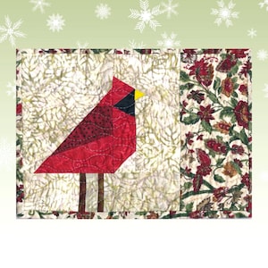 May include: A red cardinal bird with a black head and yellow beak is appliqued on a white fabric with a green and brown floral pattern. The fabric is quilted and has a red and green border.