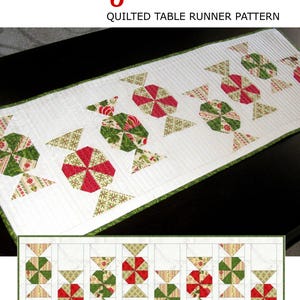 May include: White quilted table runner with a repeating pattern of red and green candy shapes. The words "Candy Carousel" are in red script at the top. The table runner has a green border and a smaller pattern of the design at the bottom.