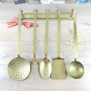 Old brass kitchen utensils. Suspension of French utensils, brass spoon, brass spatula