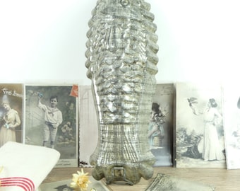 May include: A silver-colored metal fish-shaped mold for baking. The mold has a detailed design of scales and a fin on the tail.