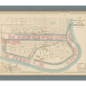 May include: Framed vintage map of Holyoke, Massachusetts, in a blue-gray frame. The map features streets, buildings, and waterways in pastel colors. Text on the map includes "Plan of the Manufacturing District of the City of Holyoke."