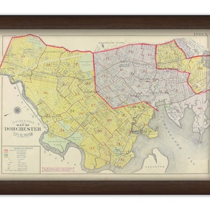 May include: A vintage map of Dorchester, a neighborhood in Boston, Massachusetts. The map is divided into numbered sections, with a key explaining the different types of buildings and streets. The map is printed on yellowed paper and has a brown frame.