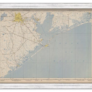 May include: A vintage map of Galveston, Texas, showing the city and surrounding areas, including the Gulf of Mexico. The map is printed on a cream-colored paper with blue and yellow accents. The map is framed in a white frame.