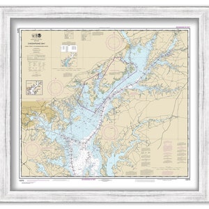 May include: A nautical chart of the Chesapeake Bay, showing the waterways and islands from the mouth of the bay to Baltimore, Maryland. The chart is printed on paper and framed in a white wood frame.