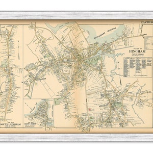 May include: A framed vintage map of Hingham, Massachusetts, in a white distressed wood frame. The map features detailed street layouts, labeled areas like Hingham Harbor, and the text "Village of Hingham, Town of Hingham".