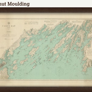 May include: A vintage map of Casco Bay, Maine, printed on cream paper with a light blue and brown color scheme. The map shows the coastline and islands of Casco Bay, with detailed markings for navigational purposes. The title "Casco Bay, Maine" is printed in the upper left corner of the map.