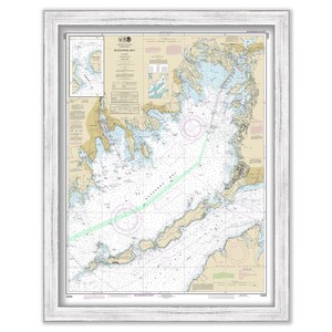 May include: A framed nautical chart of Buzzards Bay, Massachusetts. The chart is printed in black, white, and brown on a cream-colored background. The chart includes details such as depth soundings, buoys, and navigational aids.