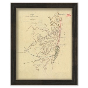 May include: A vintage map of Absecon Inlet, New Jersey, with a red line tracing the coastline. The map is framed in a dark wood frame. The text on the map reads "Sketch of the vicinity of Absecon Inlet, N.J. Scale 1/2 mile.  To accompany report of this date.  May 1st 1861.  Wm. H.  Randall, Capt. Engrs. U.S.A."
