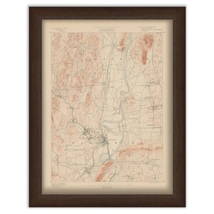 May include: Framed vintage map of Massachusetts, featuring a detailed topographical view with shades of beige, brown, and blue. The map is encased in a dark brown wooden frame, adding a classic touch to the artwork. The map includes place names.