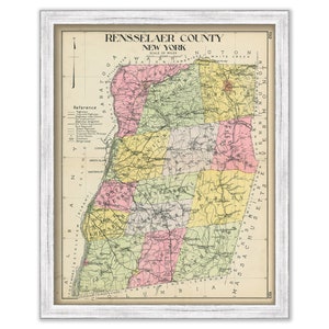 May include: A vintage map of Rensselaer County, New York, with a color-coded key for towns and cities. The map is framed in a white frame.