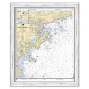 May include: A nautical chart of Salem and Lynn Harbors, Massachusetts. The chart is framed in a white wood frame. The chart shows the coastline, islands, and waterways of the area. The chart is printed in black and white with blue and yellow accents.