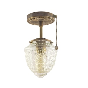 May include: A brass ceiling light fixture with a pull chain switch and a clear glass shade with a textured pattern.