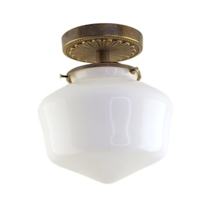 May include: A white glass ceiling light fixture with a brass base and decorative trim. The light fixture has a rounded, slightly pointed shape.