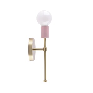 May include: A modern wall sconce with a gold-colored metal base and a pink bulb holder. The sconce features a white light bulb and a round, gold-colored wall mount. The design is minimalist and elegant, suitable for various interior styles.
