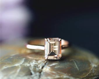 Könnte beinhalten: Ein Ring aus Roségold mit einem quadratischen, hellbraunen Edelstein.