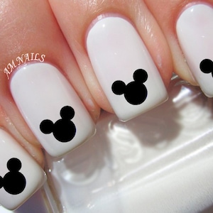 Puede incluir: Esmalte de uñas blanco con calcomanías de arte de uñas de cabeza de Mickey Mouse negra.