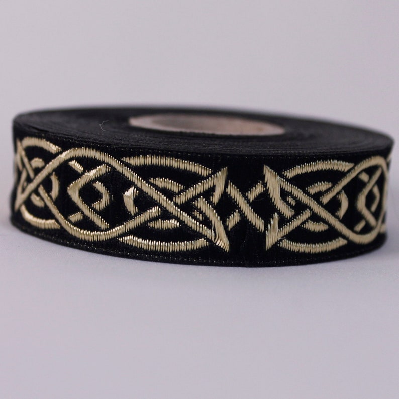 Peut inclure: Ruban noir avec un motif de n&oelig;ud celtique dor&eacute;.