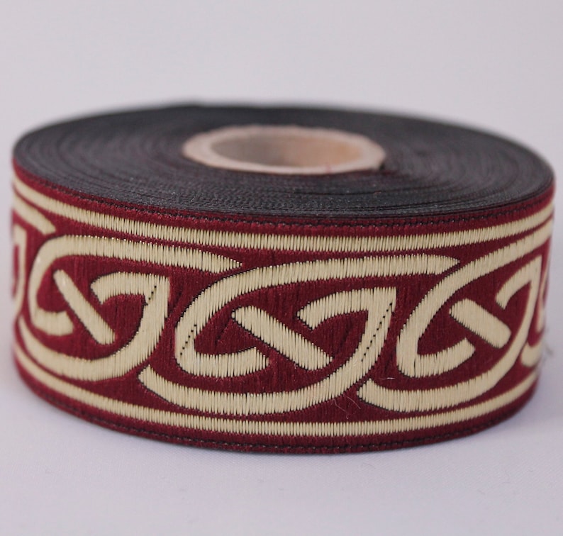 May include: A roll of burgundy and cream colored trim with a Celtic knot design.
