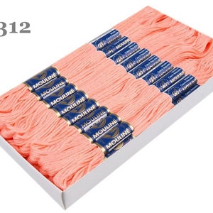 Könnte beinhalten: Eine Schachtel mit 2312 fäden von peachfarbenem Stickgarn, beschriftet mit "Mouline" in blauer Schrift.