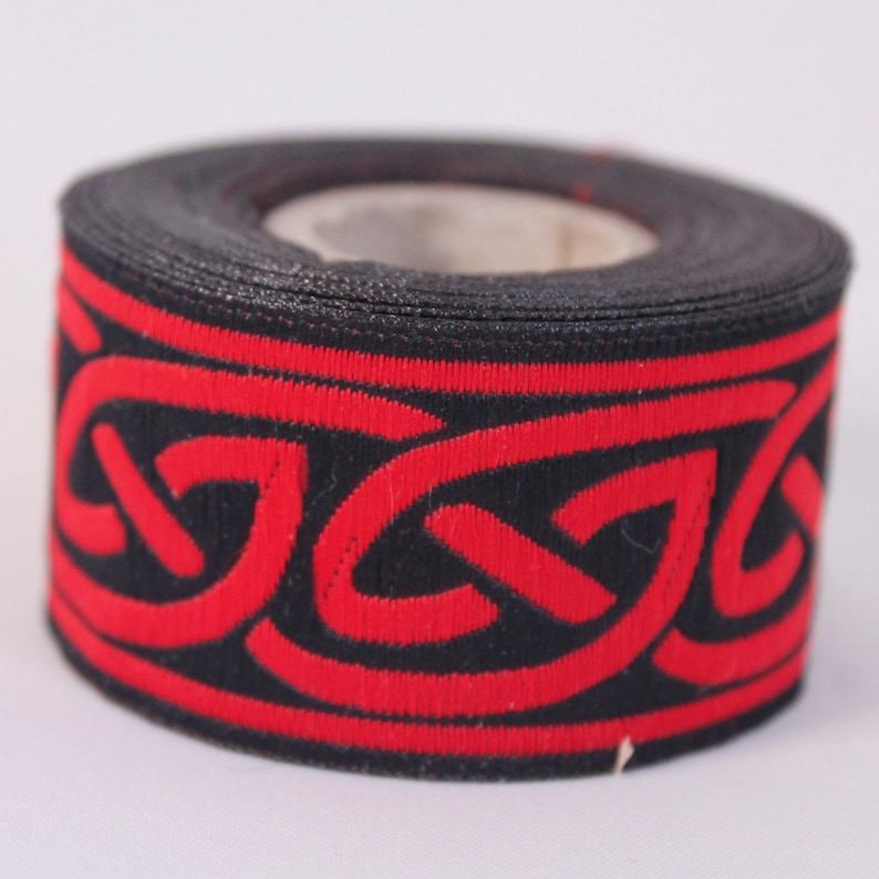 May include: A roll of black and red trim with a Celtic knot design.