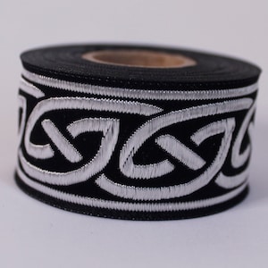 May include: A roll of black and silver trim with a Celtic knot design. The trim is approximately 1 inch wide.