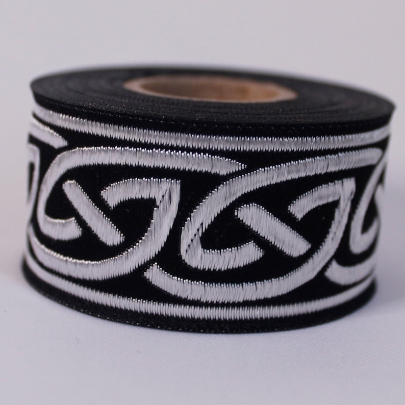 May include: A roll of black and silver trim with a Celtic knot design. The trim is approximately 1 inch wide.