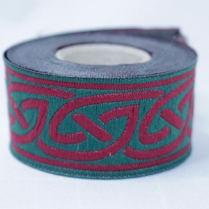 May include: A roll of green and burgundy trim with a Celtic knot design.