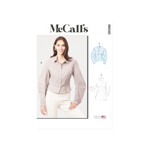 Pode incluir: Padrão de costura McCall's com uma mulher vestindo uma camisa abotoada marrom claro e calças brancas. O padrão inclui ilustrações do design da camisa e o texto "McCall's" e "M8580".
