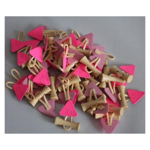 Può includere: Una collezione di accessori per capelli rosa e beige. Gli accessori includono pezzi triangolari in feltro rosa con le lettere "FS" e pezzi di legno beige. Gli accessori sono collegati con elastici beige.