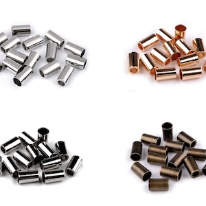 Può includere: Assortimento di tappi metallici in argento, oro e bronzo. I tappi sono piccoli, cilindrici e hanno una finitura liscia.