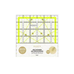 Può includere: Un righello da quilting a fessure giallo da 15,24 cm x 15,24 cm con segni neri e il logo Bohin. Il righello ha un motivo a griglia con linee diagonali ed è progettato per il quilting a patchwork.