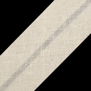 Könnte beinhalten: Nahaufnahme eines beigefarbenen Stoffbandes mit einem einzigen schwarzen Streifen, der diagonal über die Breite verläuft. Der Stoff hat eine gewebte Textur.