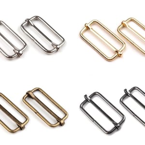 Könnte beinhalten: Vier Paare rechteckiger Metallschieber in Silber-, Gold-, Altmessing- und Gunmetal-Ausführungen. Diese Beschlagteile sind für die Herstellung von Taschen, Riemen oder andere Bastelprojekte konzipiert. Jeder Schieber hat ein Doppelstangen-Design.
