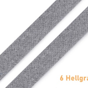 May include: Two strands of light grey braided cotton cord, with the text "6 Hellgrau" below.