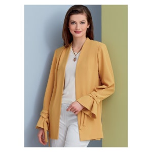 Könnte beinhalten: Ein senfgelber Blazer mit langen Ärmeln und einem Krawattendetail an den Manschetten. Der Blazer hat einen Schalkragen und eine lockere Passform.