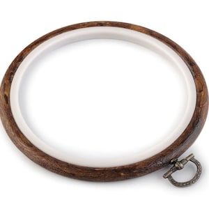 May include: A brown wooden embroidery hoop with a white inner ring and a brass clasp.