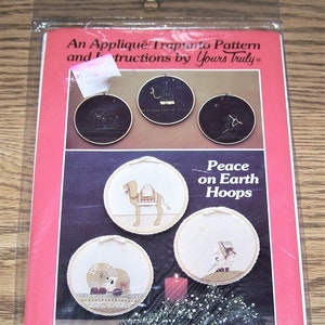 May include: A craft pattern for three 10-inch hoop designs featuring a camel, a lion, and a star. The pattern is titled "Peace on Earth Hoops" and is by Yours Truly. The pattern includes instructions for appliqué, trapunto, and finishing.