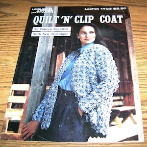 May include: A blue crochet coat with a 'Quilt 'N' Clip Coat' title and the text 'No Pattern Required' and 'With New Technique'.