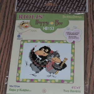 May include: A cross stitch kit featuring two cartoon ravens with the title "Happy Bee" and the product number "HB153". The kit is labeled as a "Cross stitch kit" and "Набор для вышивания крестом" (Russian for "Cross stitch kit"). The kit is for kids and beginners and includes a design of two ravens with the text "Karl u Klary..." (German for "Karl and Klary..."). The kit measures 6 1/4 inches by 5 inches.
