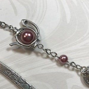 May include: Silver bookmark with a teapot charm and a teacup charm. The charms are accented with pink beads.